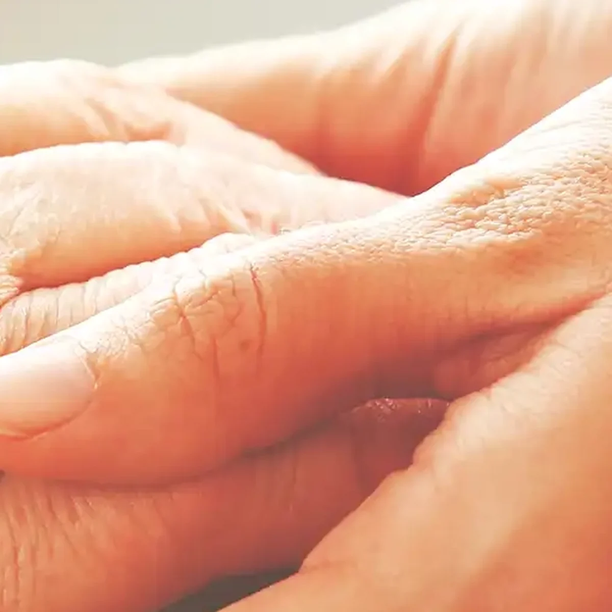 Compassionate caregiver holding the hand of an older adult